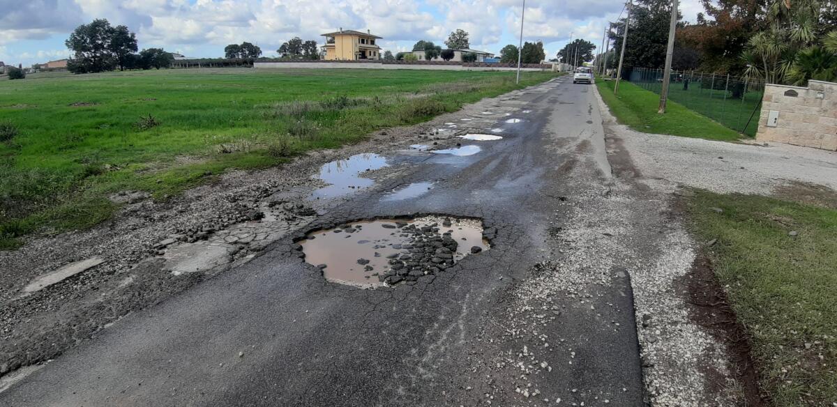 Manto stradale disastrato lungo via Carano, ad Aprilia. “Il Comune intervenga”. - 