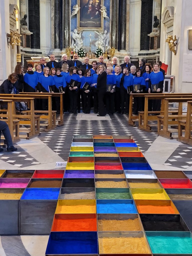 Il coro, davanti l'opera "Croce di Luce"