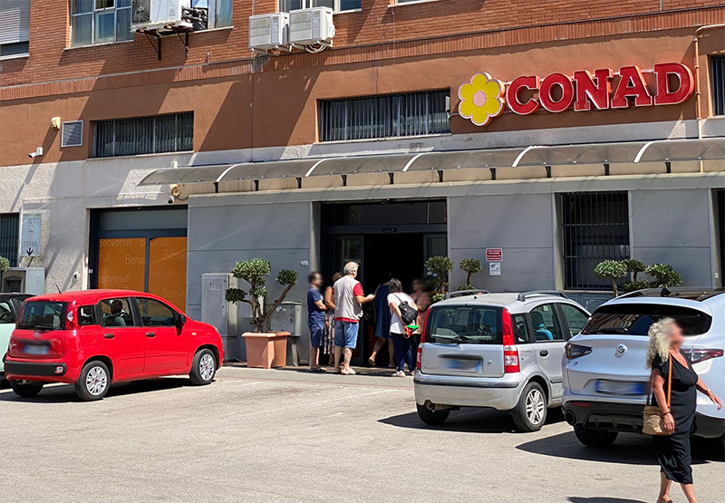 la clientela ed il personale del Conad di via dei Mille, ad Aprilia, attendono fuori per via dell'interruzione dell'energia elettrica.