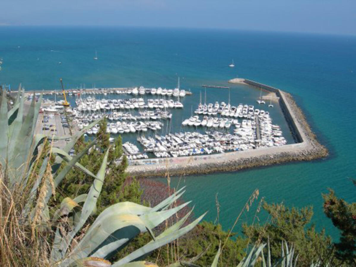 Una barca a vela, a causa del forte vento, si spiaggia all’imboccatura del porto di San Felice Circeo. - 